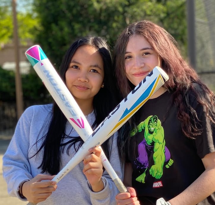 Two girls with softball bats. 